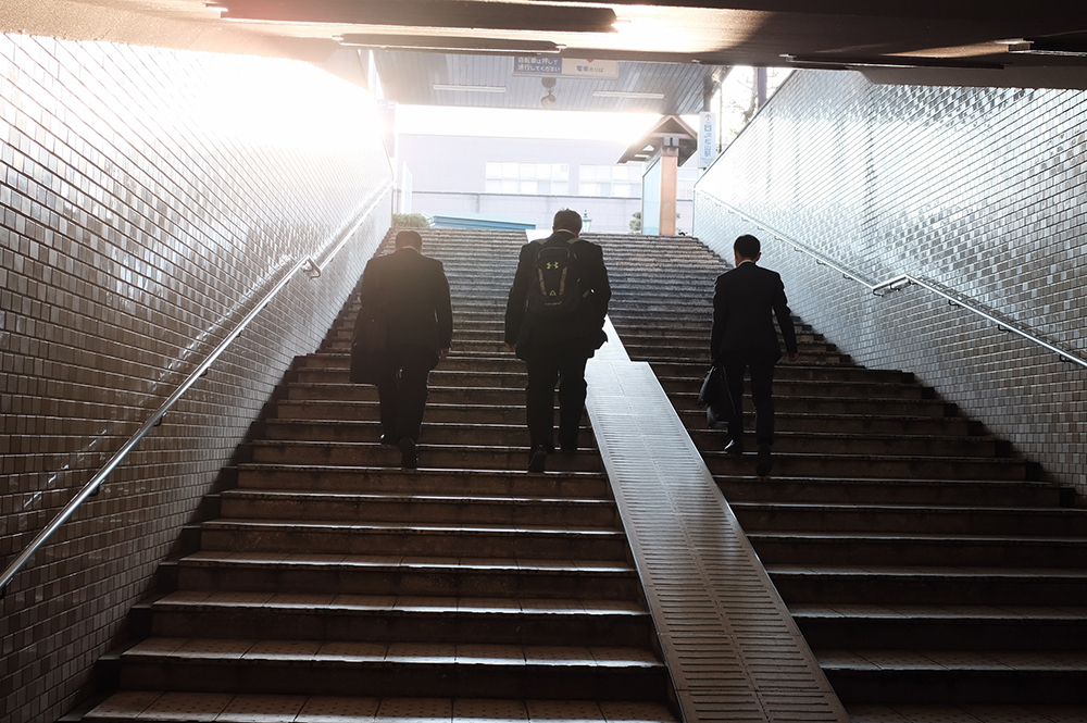 Businessmen walking up stairs - Credit Mak
